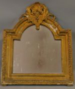 A 19th century carved giltwood arched wall mirror with shell and foliate cresting. 74x61cm