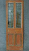 A 19th century pitch pine door with inset coloured leaded glass panels. H.196 W.66cm