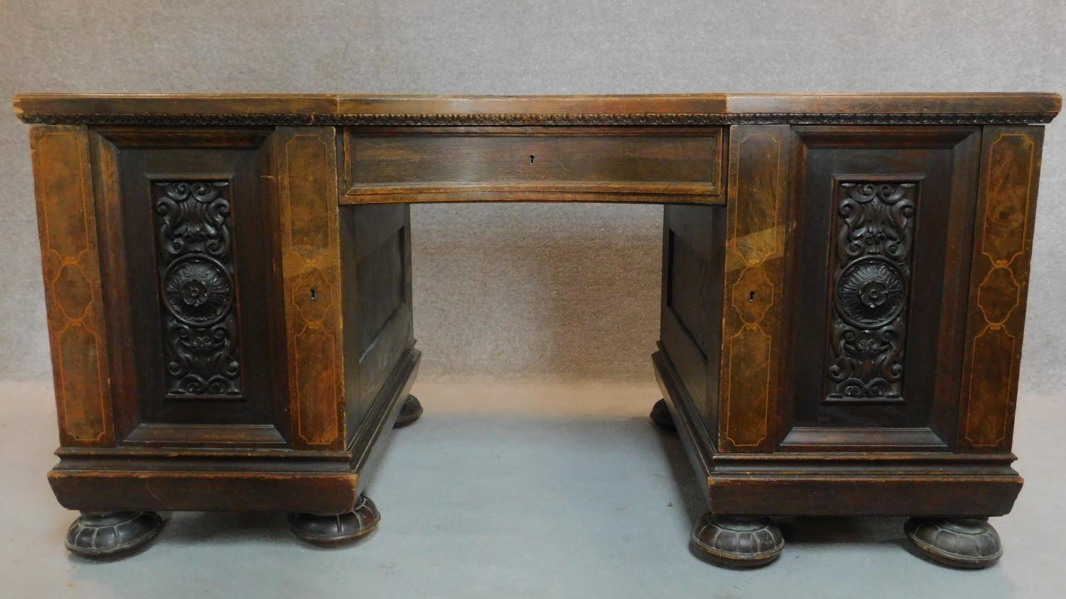 A continental oak and walnut kneehole desk fitted cupboards enclosing slides on reeded bun feet. H. - Image 2 of 7