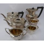 A silver six piece tea service with ebony handles and finial, coffee pot, tea pots, water jug, two