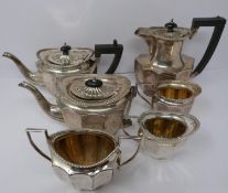 A silver six piece tea service with ebony handles and finial, coffee pot, tea pots, water jug, two