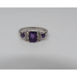 An Amethyst and diamond 18ct white gold ring, set to centre with a emerald cut amethyst in a four