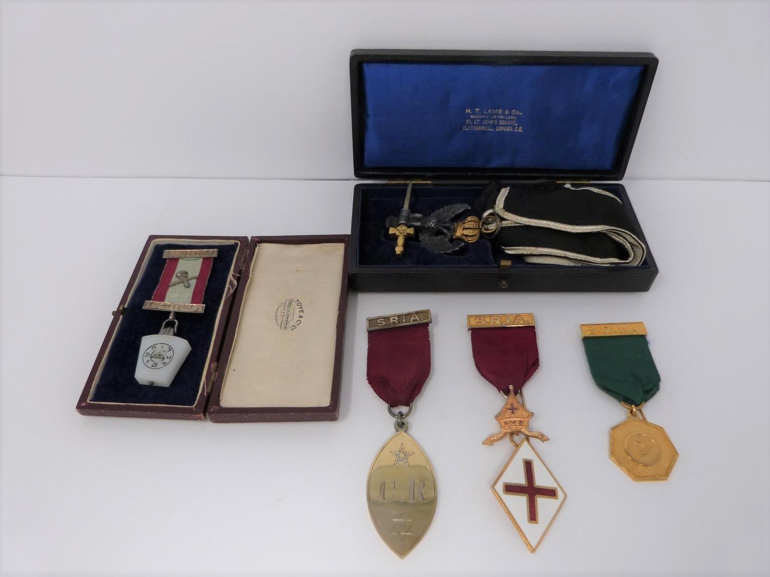 A group of Masonic medals, five including two silver, a double headed eagle holding sword with