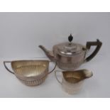 A three piece silver tea set, sugar, tea pot and milk jug, tea pot and helmet jug Ebony handle by