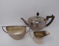 A three piece silver tea set, sugar, tea pot and milk jug, tea pot and helmet jug Ebony handle by