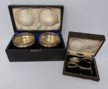 A pair of raised pierced cups in leather case and cased childs spoon and pusher, cups by Deakin