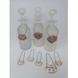 Three cut glass decanters with silver drinks labels and five ceramic drinks labels (Sherry,