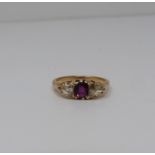 A three stone Ruby and rose cut diamond yellow metal ring, set to centre with a cushion shaped old