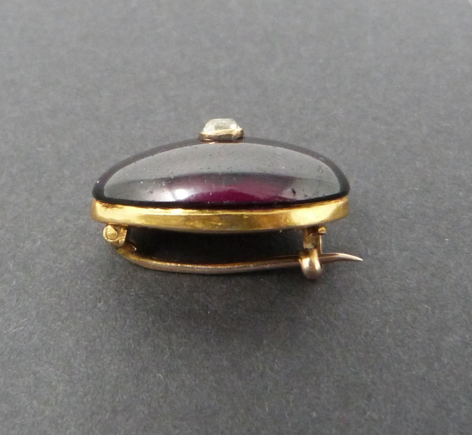 A Georgian/Victorian yellow metal oval garnet brooch inset with diamond, hollow foil backed cabochon - Image 3 of 6