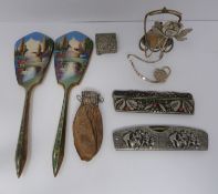 A collection of collactibles including, two enamel mirrors, two white metal combs, a leather coin