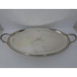 A large silver oval tray, monogrammed with H, round pebble feet, foliate design handles, ridged rim,