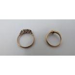 Two gold gemset rings, one cross-over design with a round brilliant diamond with an approximate
