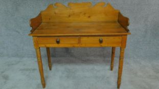 A Victorian pine washstand with raised shaped back and two frieze drawers on turned tapering