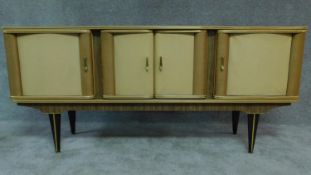 A vintage 1960's sideboard by Stonehill Furniture fitted four doors enclosing drawers on tapering