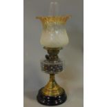A late Victorian oil lamp with brass base on ebonised socle. H.57cm