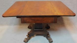 An early 19th century mahogany drop flap dining table fitted end drawer on quadruped platform base