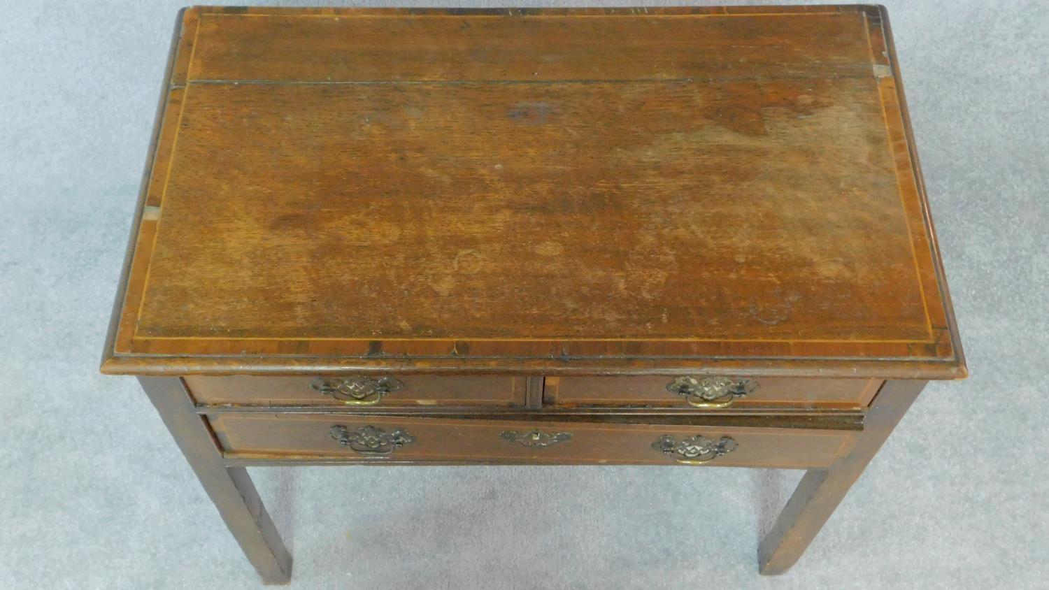 A Georgian country oak lowboy with mahogany crossbanding and satinwood stringing, two short over - Image 4 of 8