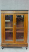 A Victorian walnut and inlaid pier cabinet with two glazed doors on plinth base and turned feet. H.