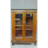 A Victorian walnut and inlaid pier cabinet with two glazed doors on plinth base and turned feet. H.