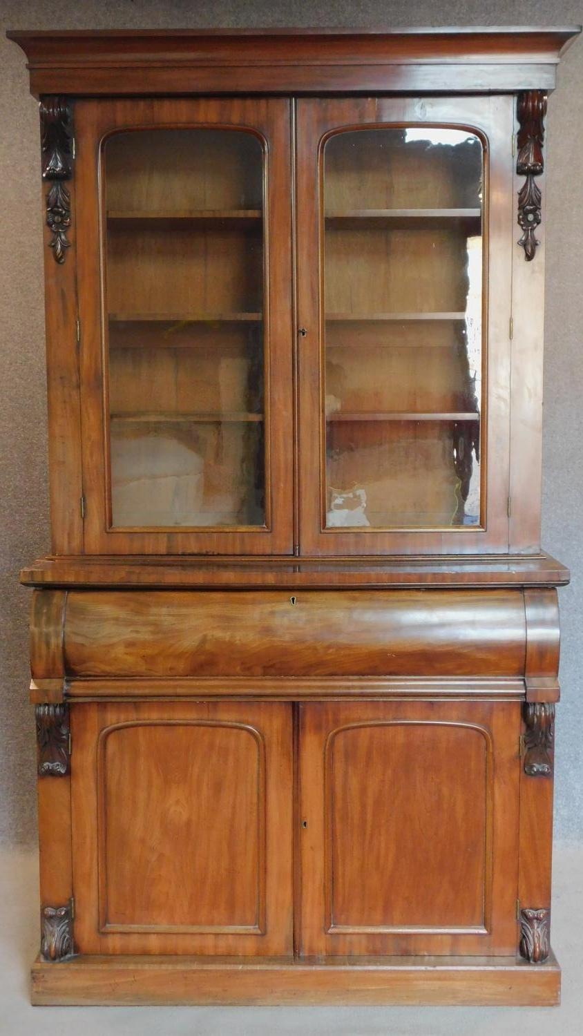 A mid Victorian mahogany two section library bookcase, the upper glazed section above well fitted