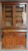 A mid Victorian mahogany two section library bookcase, the upper glazed section above well fitted