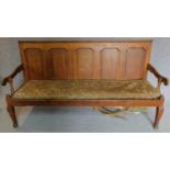 An antique country oak panelled back settle on cabriole supports. w105x193x62cm