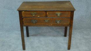 A Georgian country oak lowboy with mahogany crossbanding and satinwood stringing, two short over