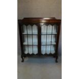 An Edwardian mahogany glazed door display cabinet on cabriole ball and claw supports. 128 W.105 D.