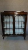 An Edwardian mahogany glazed door display cabinet on cabriole ball and claw supports. 128 W.105 D.