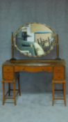 A mid 20th century walnut and burr maple dressing table with ebonised and mother of pearl inlay,