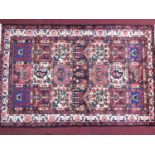 A North West Persian Bakhtiari rug, repeating floral panel motifs within stylised ivory floral