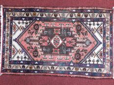 A Persian Shiraz style rug, central pendant on a rouge and cream ground, within floral border and