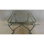 A wrought iron garden table with square bevelled glass top. H.73 W.115 D.115cm
