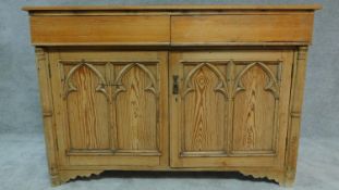 A 19th century pitch pine ecclesiastical style two door sidebaord. H.98 W.143 D.53cm