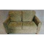 A 2 seater sofa in sage faux suede upholstery. 88x145x93cm