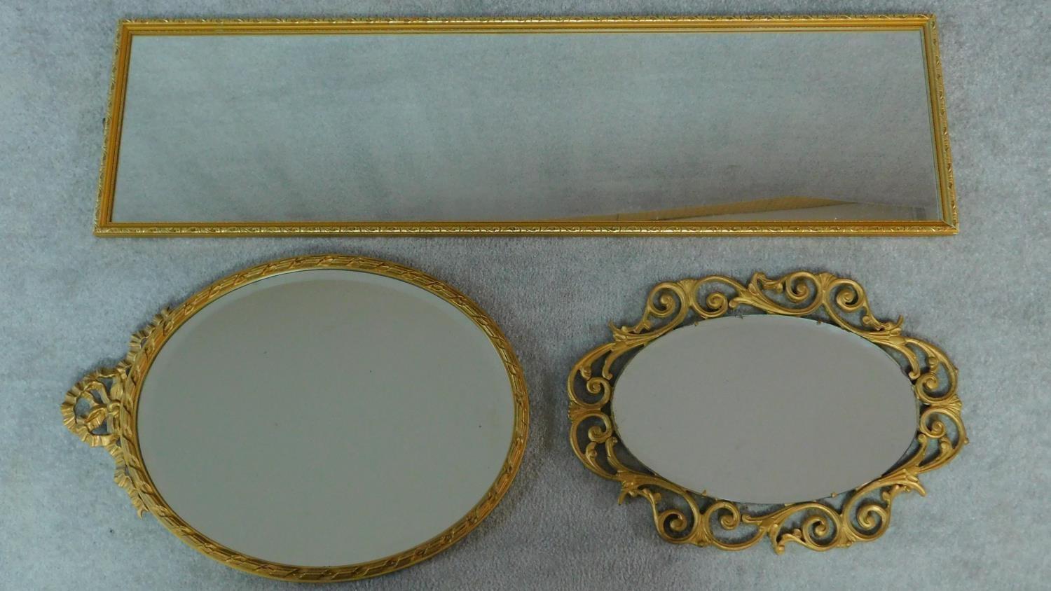 A rectangular gilt wall mirror and two oval gilt mirrors. 120x34cm