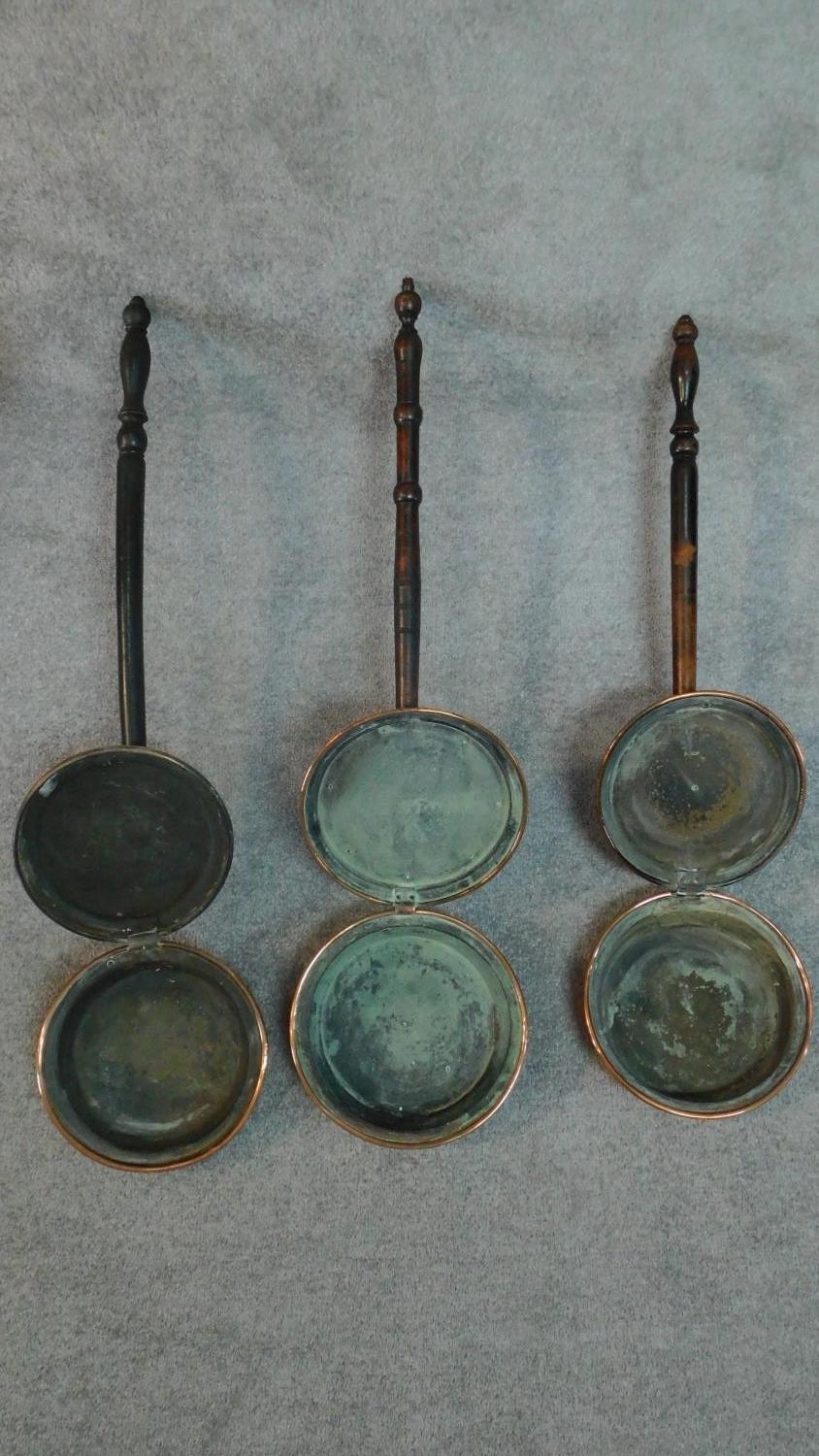 A collection of three 19th century copper warming pans with turned handles. W.116cm. - Image 4 of 6