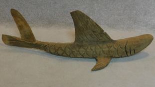 A carved wooden figure of a flying fish. W.120cm