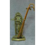 A cast metal Colebrookdale style hall stand and a collection of walking sticks. H.93