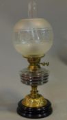 A late Victorian oil lamp with etched glass shade and brass base on turned ebonised socle. H.55cm