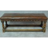 A country oak antique style footstool with tan leather stuffover seat. H.35 W.92 D.31cm