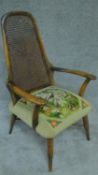 A mid 20th century beech framed armchair with caned back and stuffover tapestry seat. H.100cm