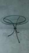 A wrought iron and glass topped conservatory table. H.78 W.92 D.92cm
