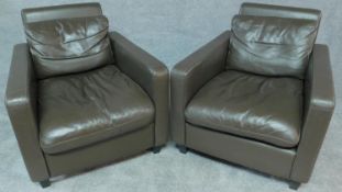 A pair of compact size armchairs in tobacco leather upholstery. H.77cm
