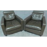 A pair of compact size armchairs in tobacco leather upholstery. H.77cm