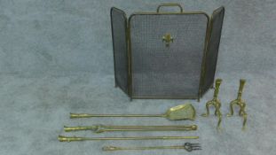 A set of 19th century brass fire implements and the matching andirons and a three section fireguard.