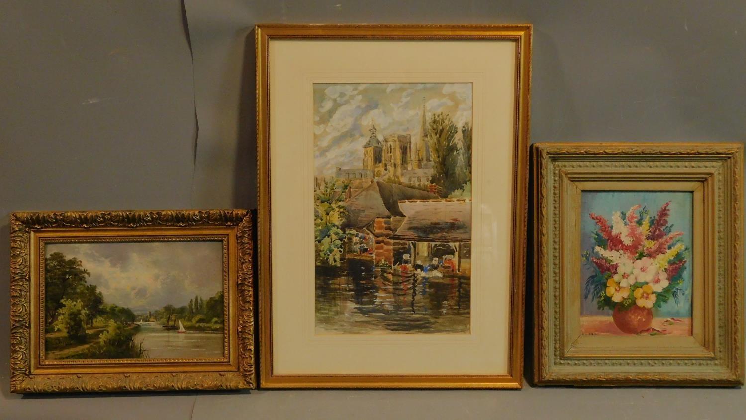 A framed and glazed watercolour, cathedral by a river, and two framed oil paintings, still life