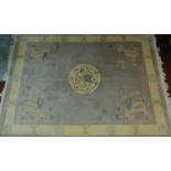 A Chinese rug with central medallion on a mink field with floral spandrels encompassed with a