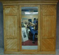 A Victorian pitch pine aesthetic style triple section compactum wardrobe with fitted mirrored