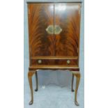 A Georgian style flame mahogany drinks cabinet with mirrored glass interior. H.129 W.66 D.42cm